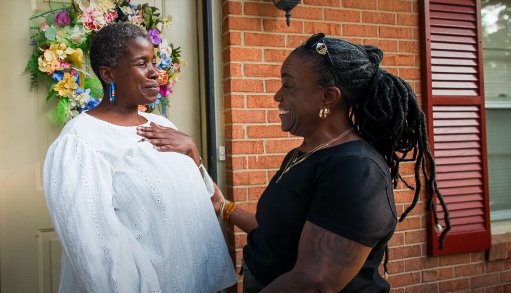 A Catholic Charities client and her mentor smile together